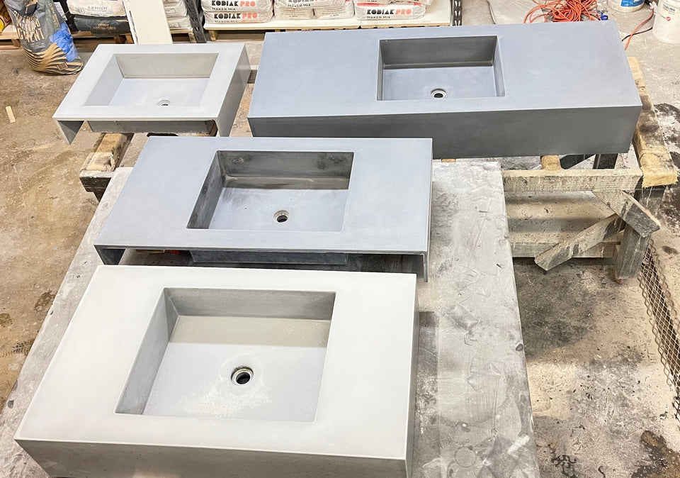 Muitlple sizes and colors of concrete sinks, unfinished, in the work shop